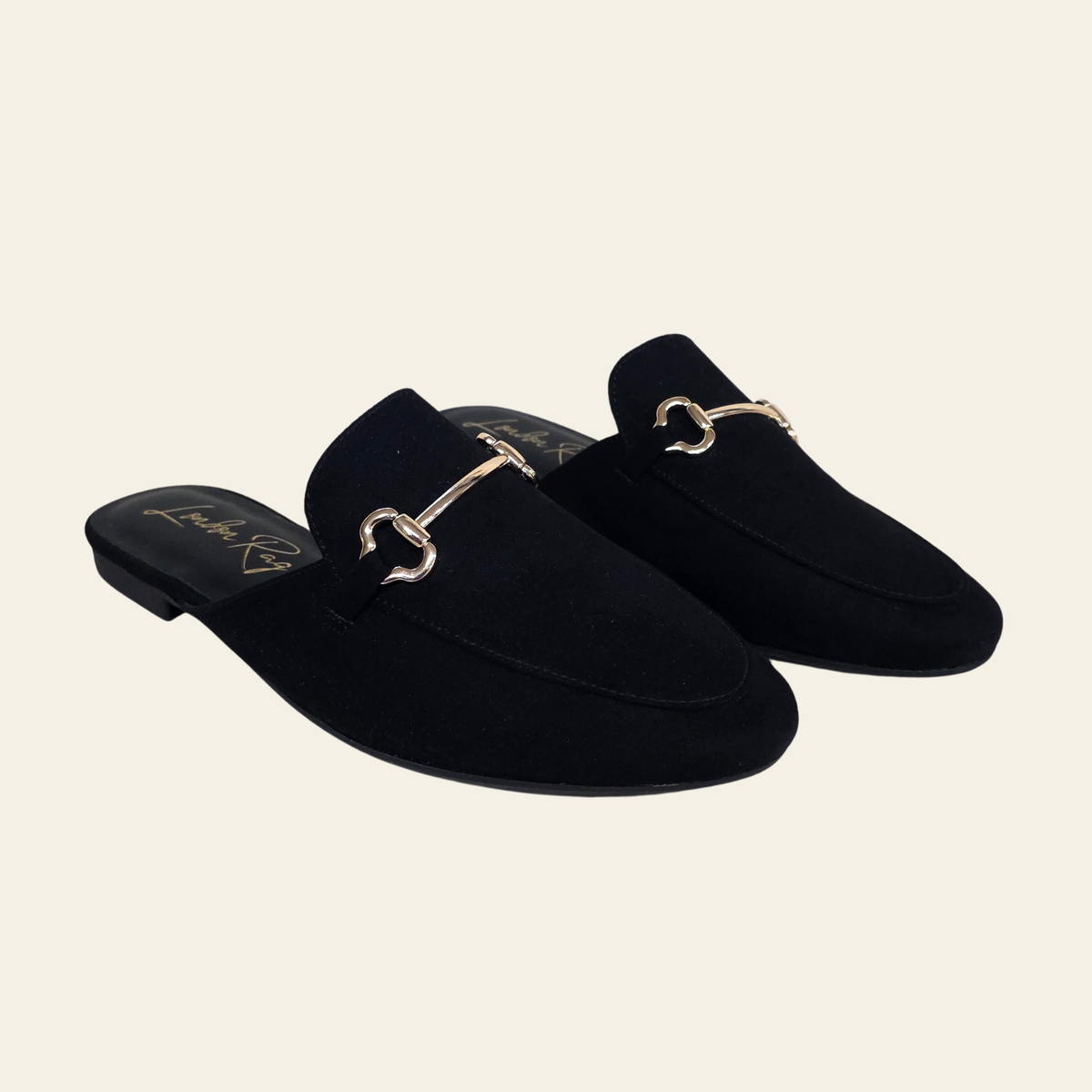 The Alpine black suede mule loafers worn with black dress pants.