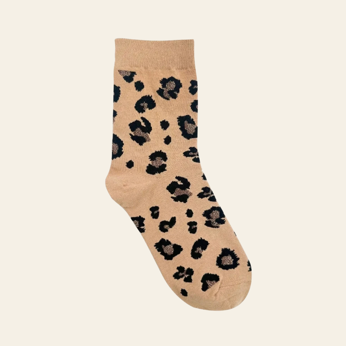 A single ankle sock with a beige base and a black leopard print pattern, shown against a solid off-white background.
