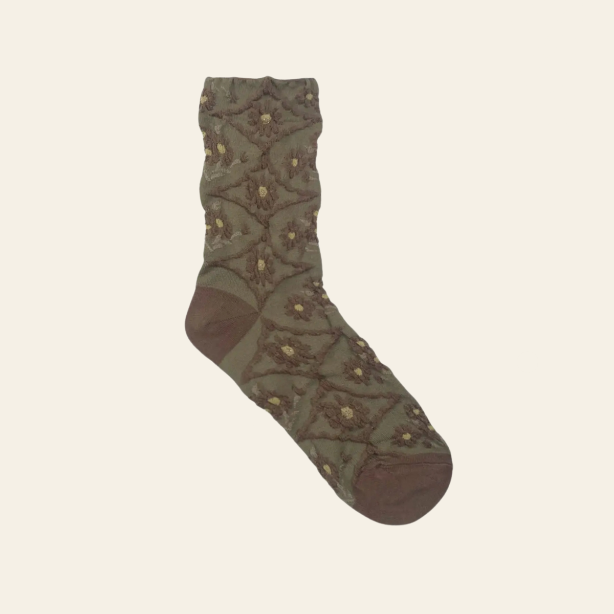 An olive green crew sock with a brown geometric pattern and small gold accents, displayed on a light cream background.