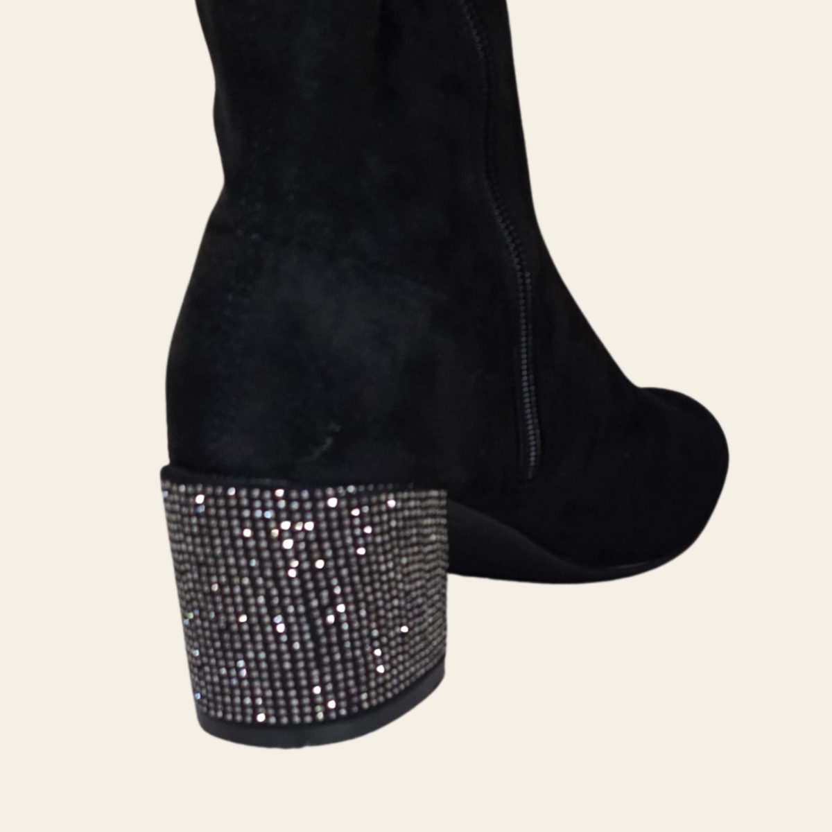 A pair of black suede ankle boots with high stiletto heels, platform soles, and decorative silver rhinestone embellishments with dangling fringe, shown against a solid light beige background.