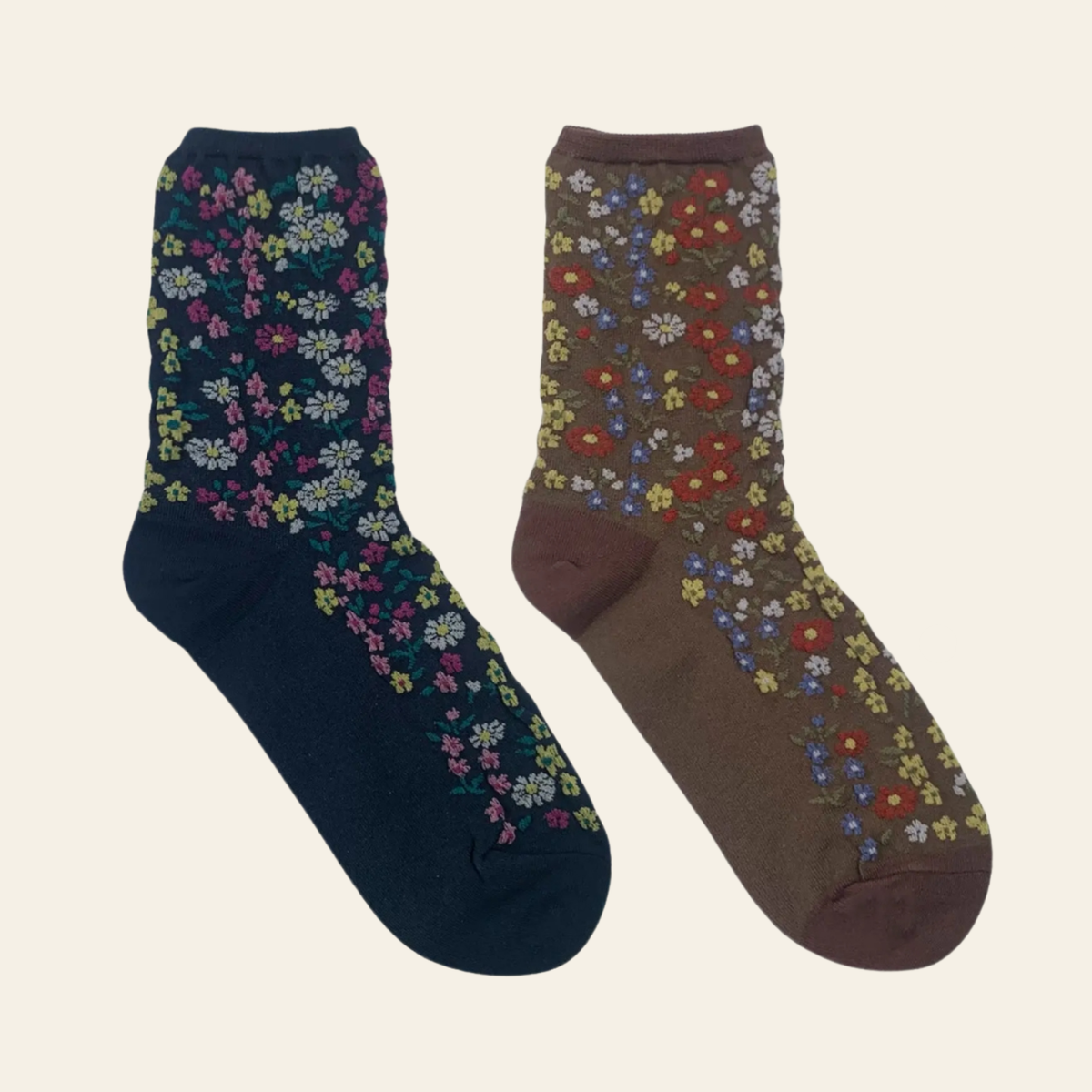 Two crew socks with floral patterns, one in navy blue and one in brown, displayed against a light cream background.