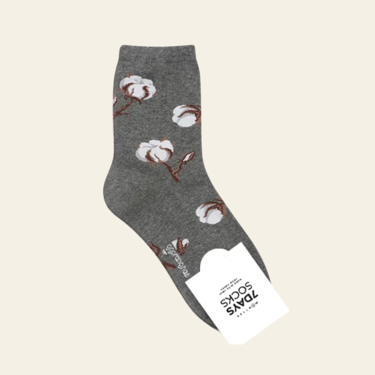 A single dark gray crew sock with a white and brown cotton boll pattern, shown with its white paper tag attached against a solid light beige background.