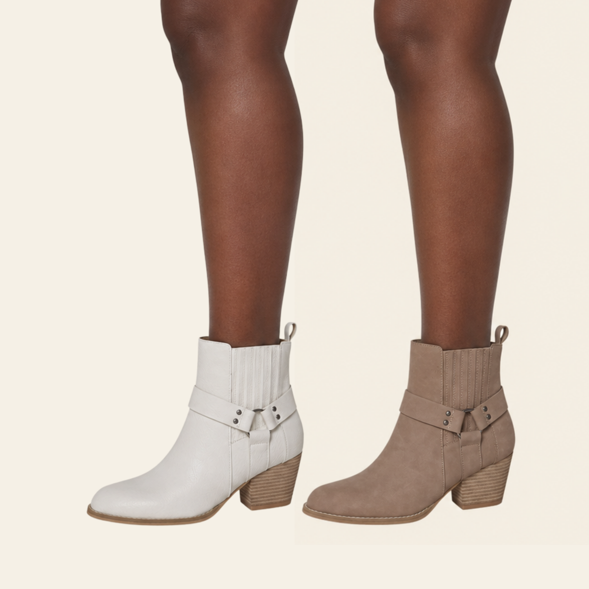 A pair of women's ankle boots shown on a model's feet, featuring a white leather boot on the left and a taupe suede boot on the right, both with stacked block heels and decorative straps.