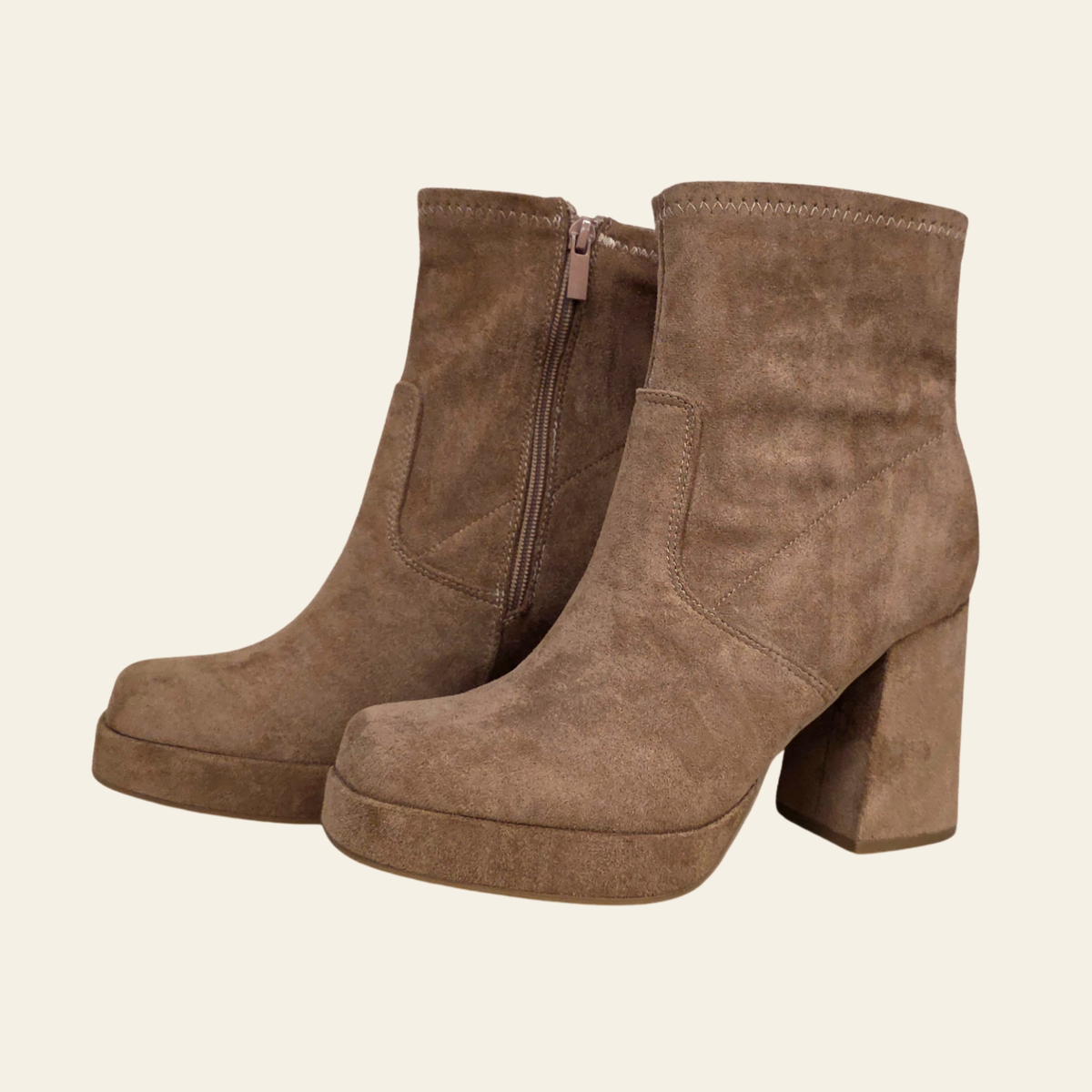A pair of women's brown suede ankle boots with block heels and platform soles, shown on a plain light beige background.