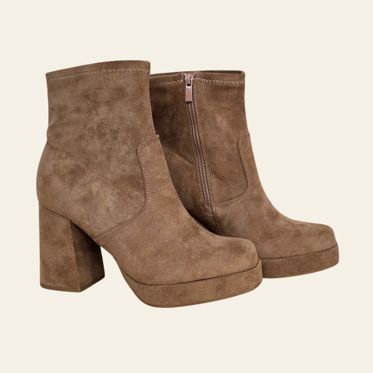 A pair of women's brown suede ankle boots with a chunky block heel and side zipper, shown on a light cream background.