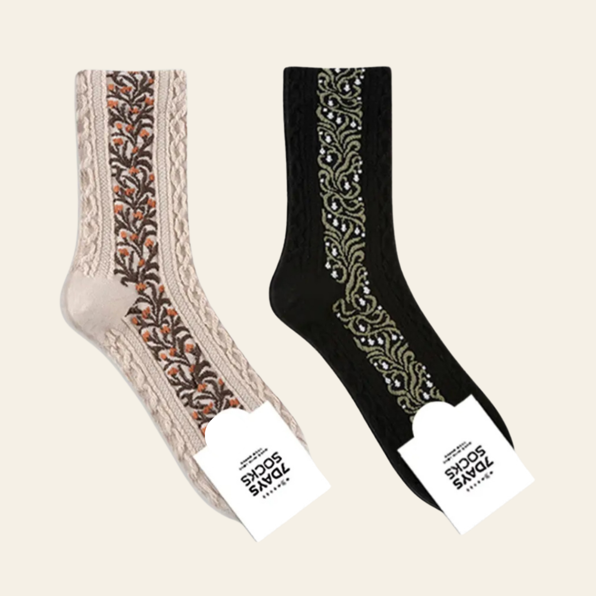 Two decorative crew socks shown on a light beige background: one beige sock with a brown and orange floral lace panel, and one black sock with a green and white floral lace panel. Both have white paper tags reading '700 SOCKS'.