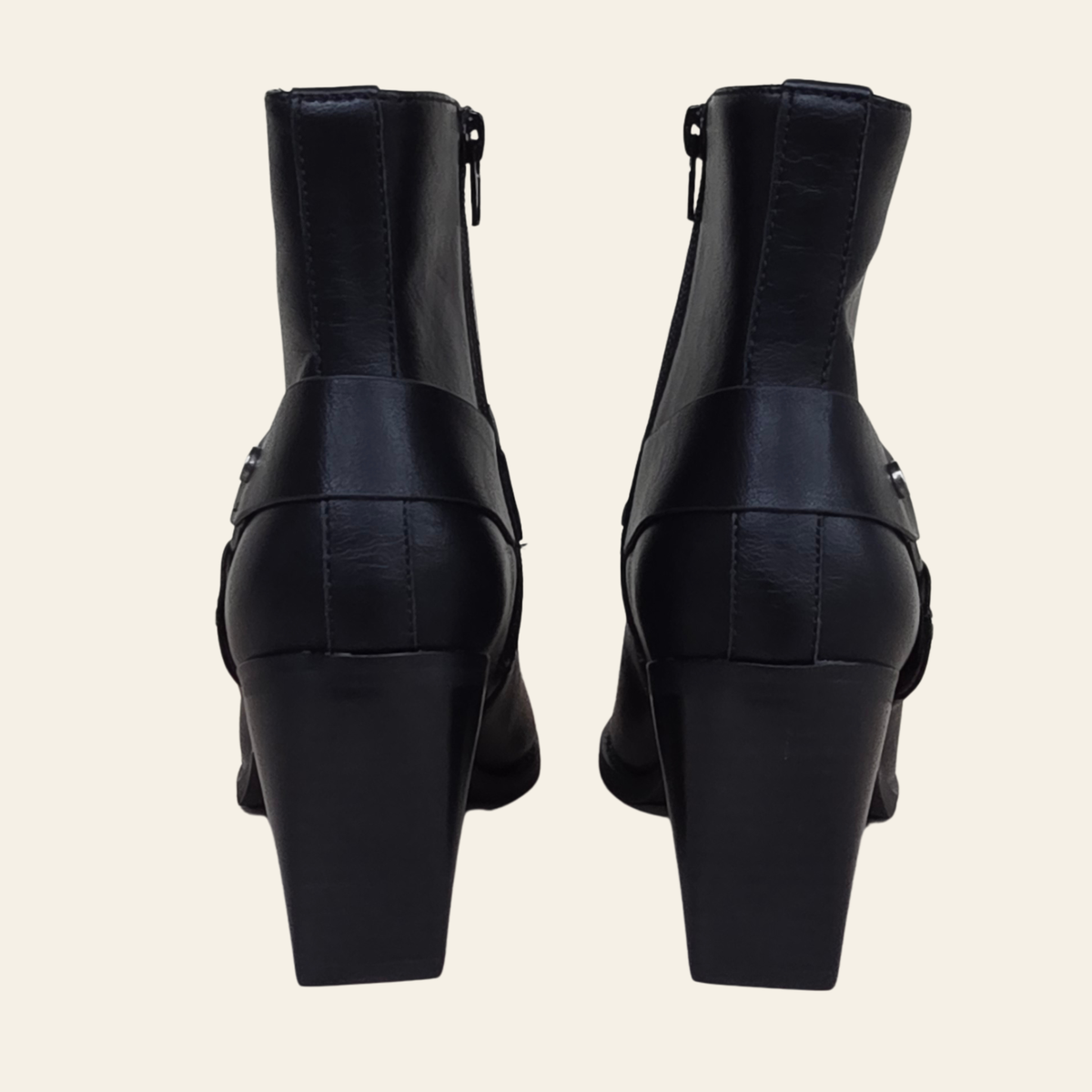 Black leather ankle boots with block heels and side zippers, shown from the back on a light cream background.