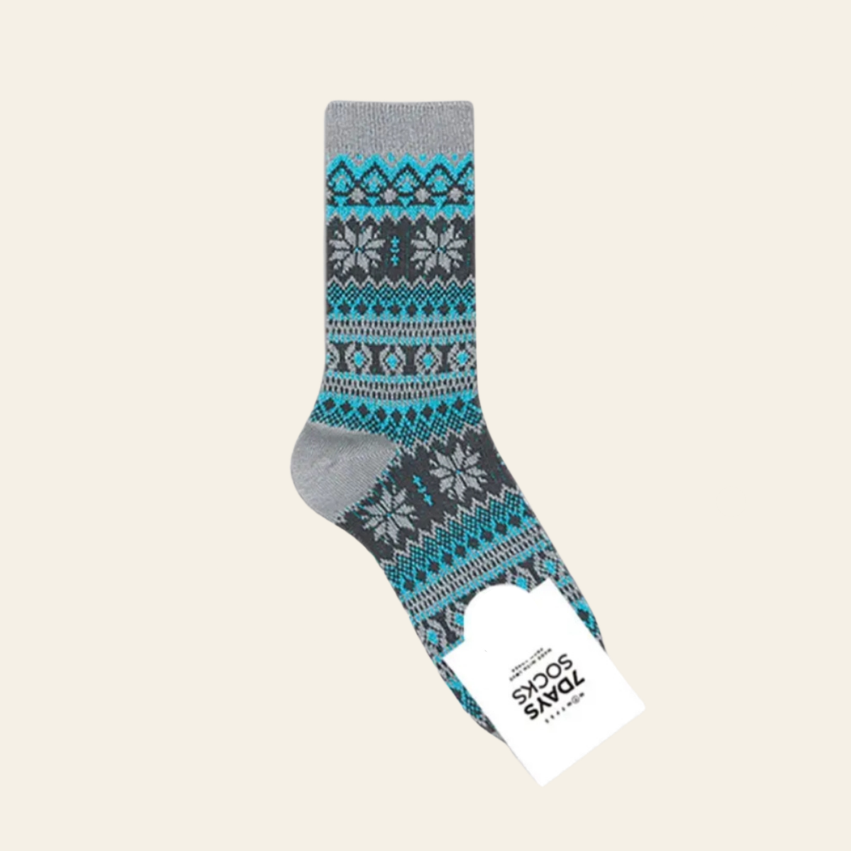 A single crew sock with a gray base and a colorful Fair Isle pattern in teal, dark gray, and white, featuring a white paper tag with the brand name 'SPOONS FOR Socks' attached, set against a solid light beige background.