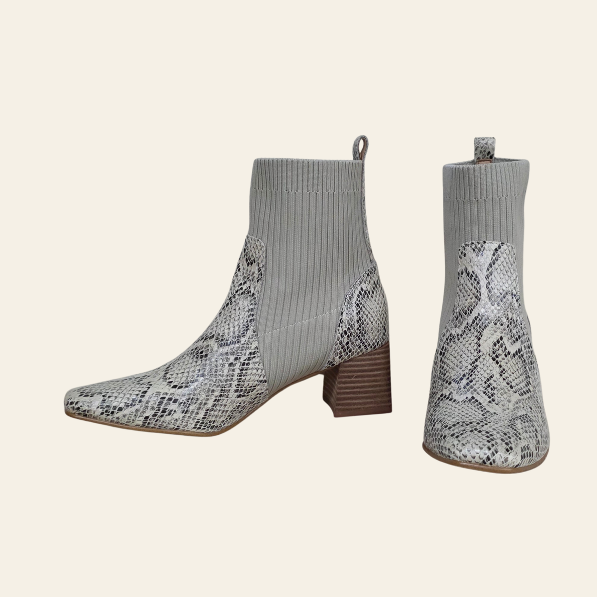 A pair of gray ribbed knit ankle boots with a snakeskin-patterned leather overlay and stacked block heels, shown from side and back angles on a light beige background.