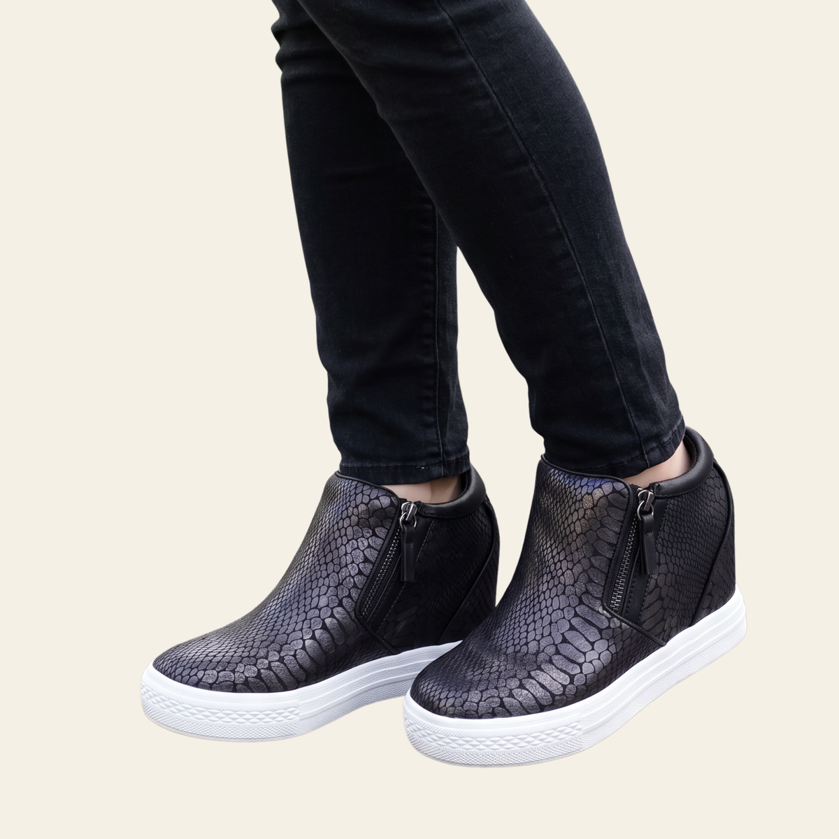Black textured wedge ankle boots with side zippers and white platform soles, shown on a model wearing black jeans against a light beige background.