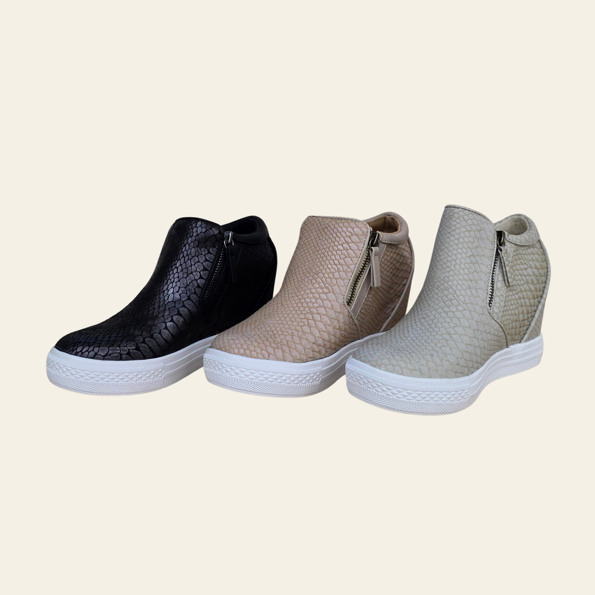 Three ankle slip-on shoes with a textured python-style embossed pattern, shown in black, blush, and cream colorways on a solid cream background.