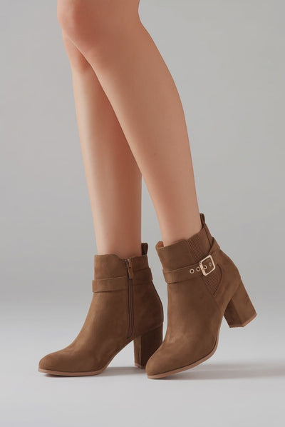 Model wearing camel brown ankle boots with slight movement to show off the boots.