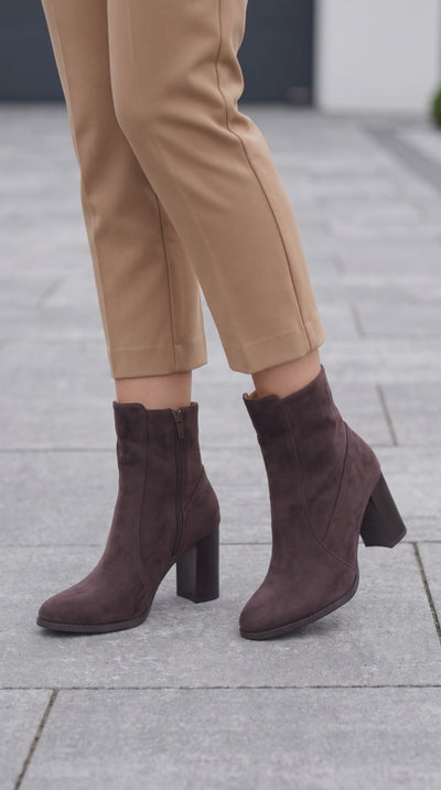 Soko Brown boots on model walking on sidewallk.