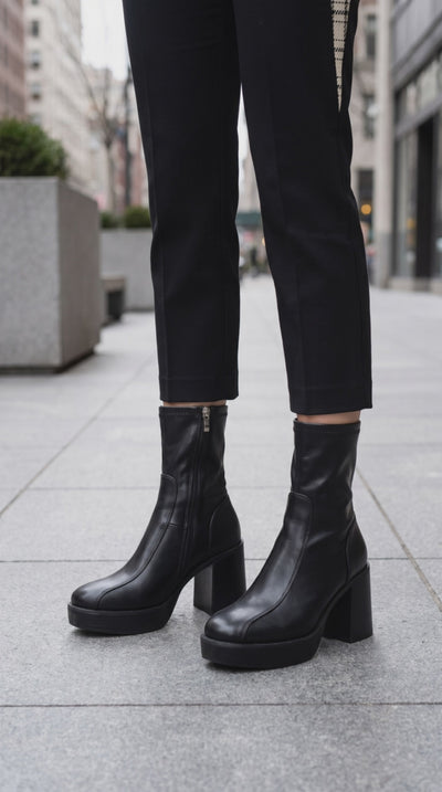 Model wearing JOSEPHINE platform black faux leather boots.