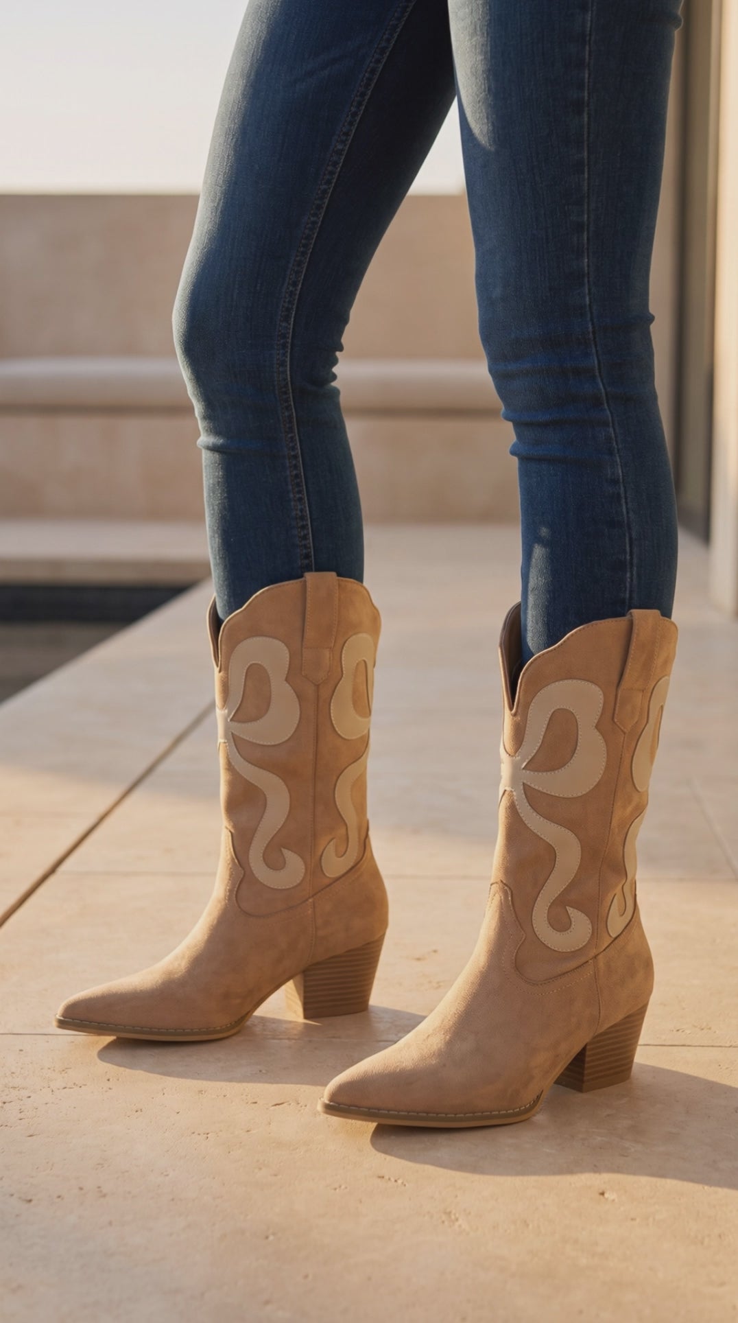 Model wearing almond suede western boots with cream inlay design and block heels, stepping and turning to show the boots from different angles.