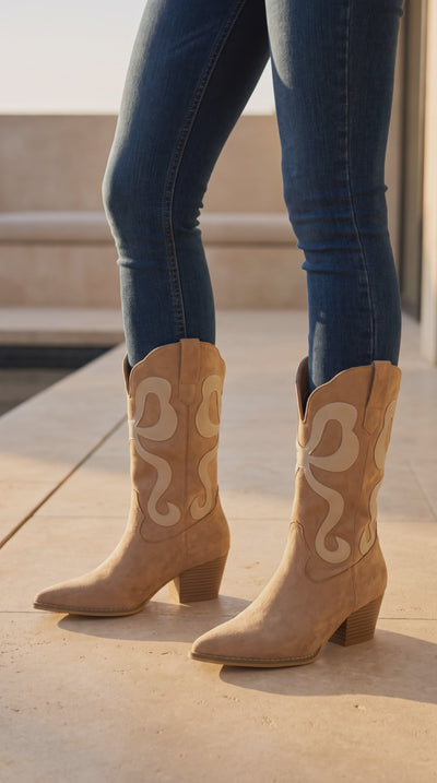 Model wearing almond suede western boots with cream inlay design and block heels, stepping and turning to show the boots from different angles.