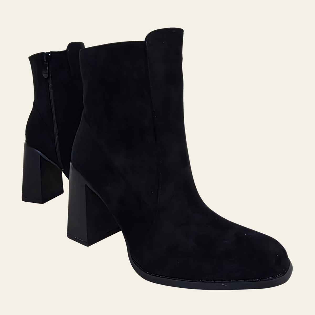 A pair of black suede ankle boots with chunky block heels, shown from a three-quarter angle against a solid off-white background.